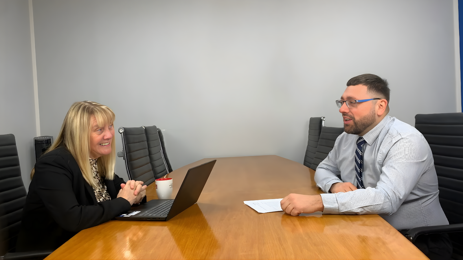 Business owner reviewing a Safe Launch IT support switch plan with a managed IT provider in a meeting room.