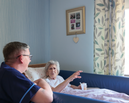 A member of staff with a resident in her bedroom at St Bartholomew’s Court